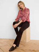 Dark brown high-rise bootcut velvet pants, showing soft texture and slight flare at the ankle.