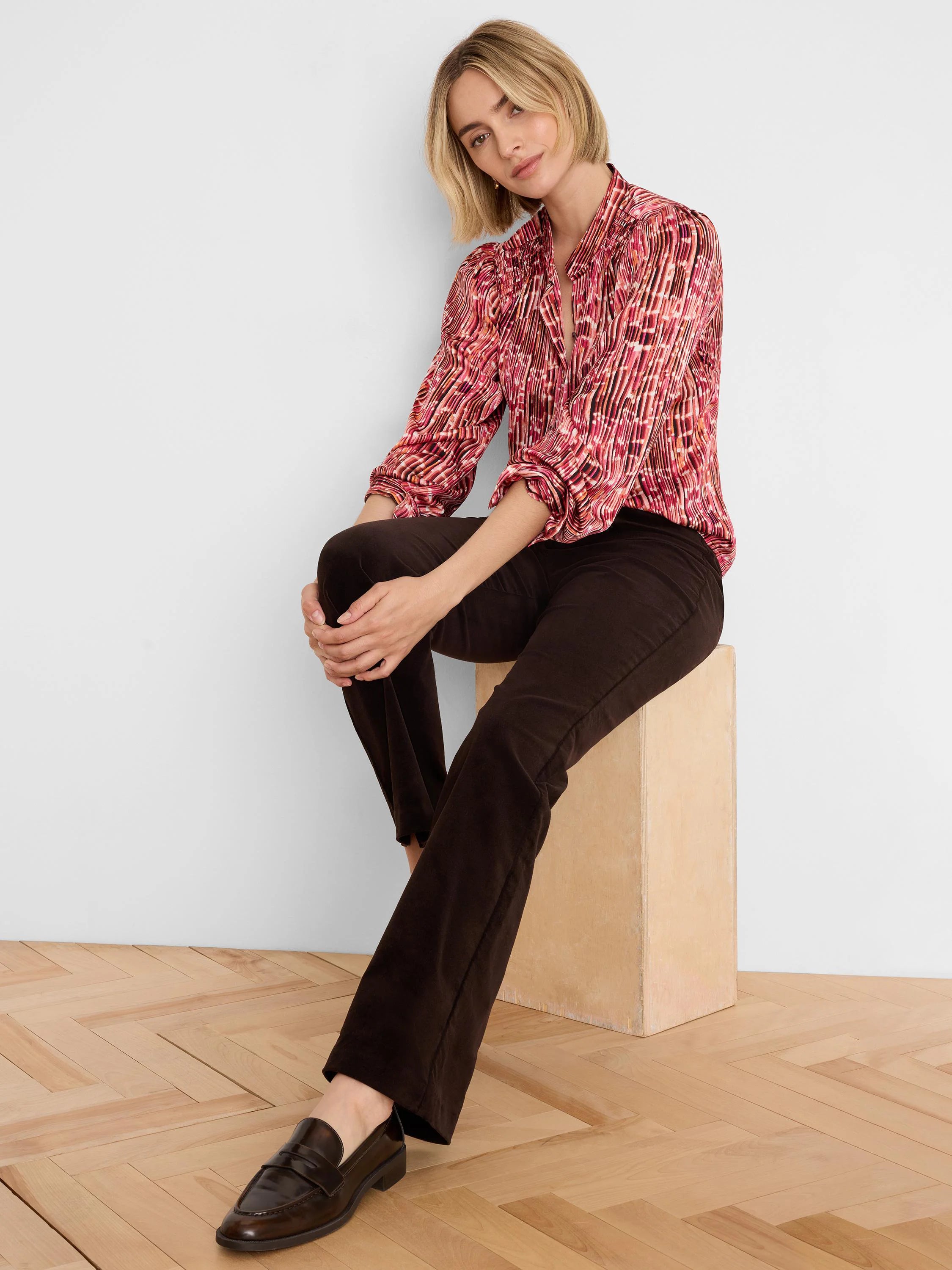 Dark brown high-rise bootcut velvet pants, showing soft texture and slight flare at the ankle.