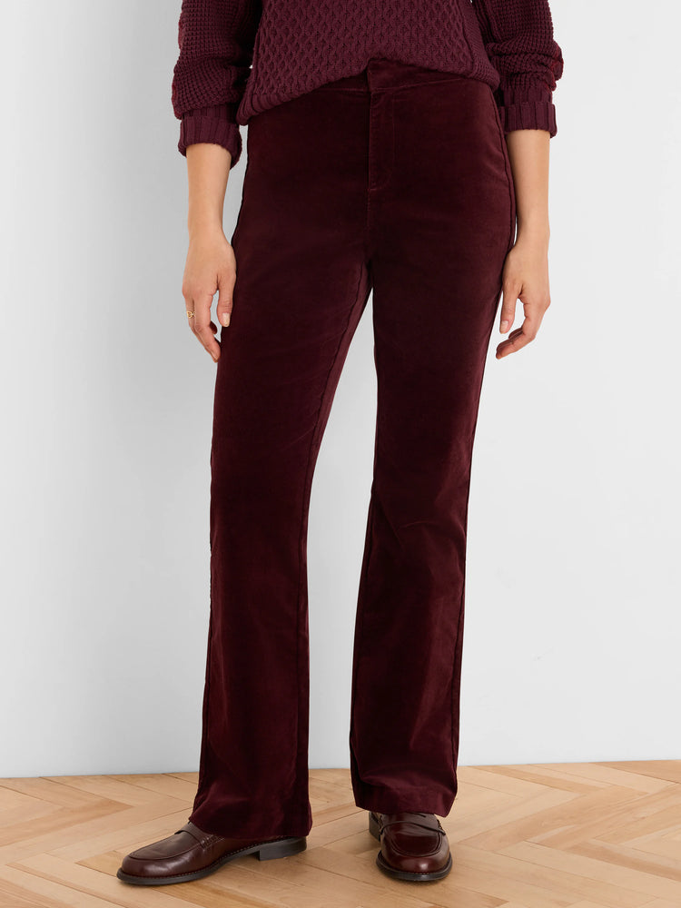 Burgundy high-rise velvet boot-cut pants on a person, paired with a matching sweater and dark brown loafers.