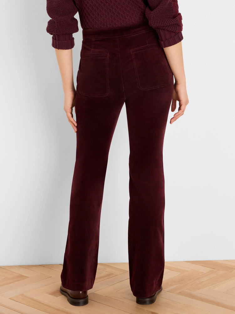 Rear view of burgundy velvet high-rise boot-cut pants with two back patch pockets.