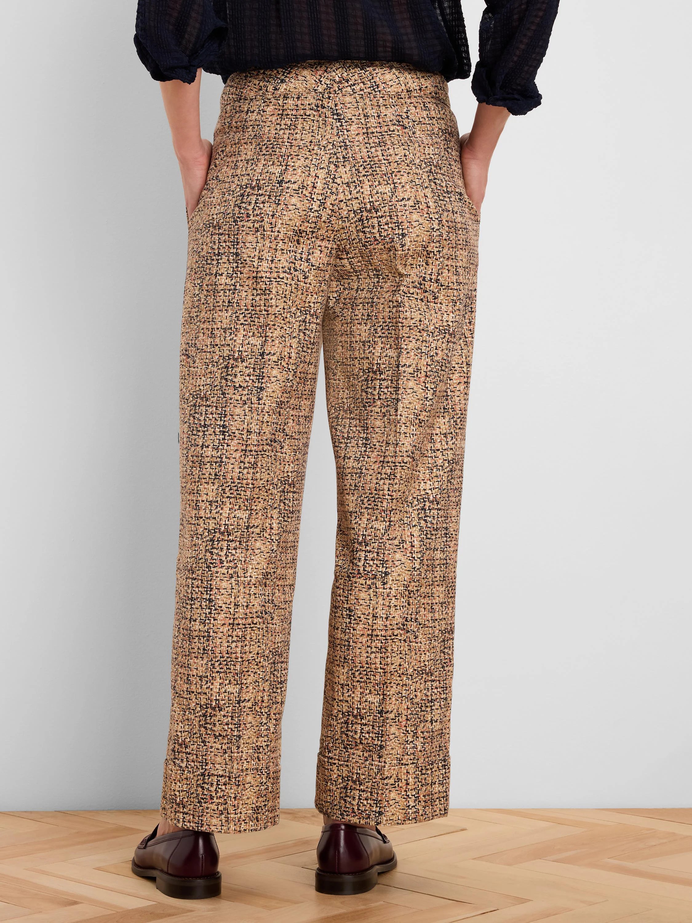 Tweed ankle pants with cuffed hems, patterned in tan, black, and rust flecks, shown from the back.
