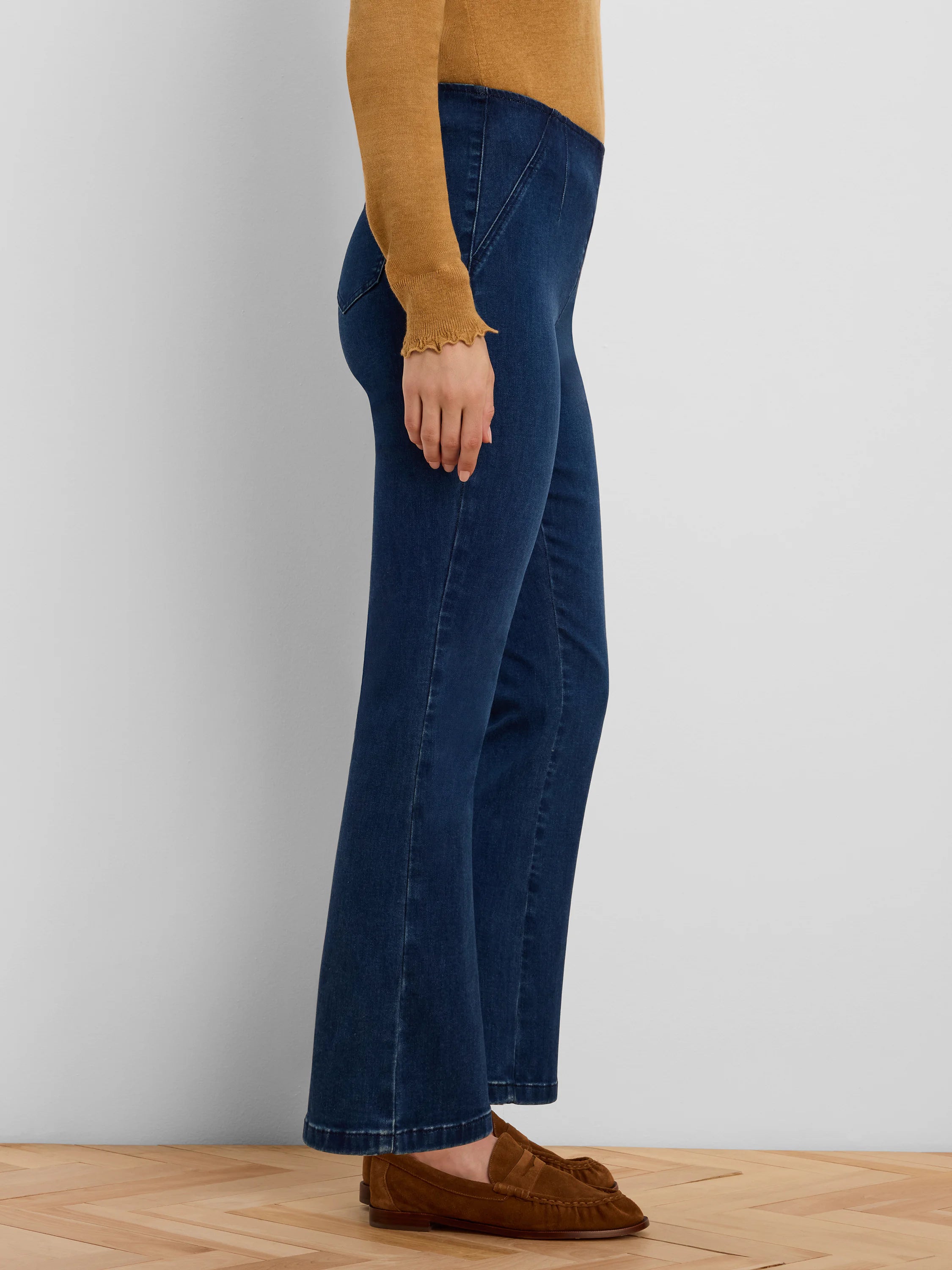Dark blue boot-cut jeans with flared legs and angled front seams on the upper thigh.