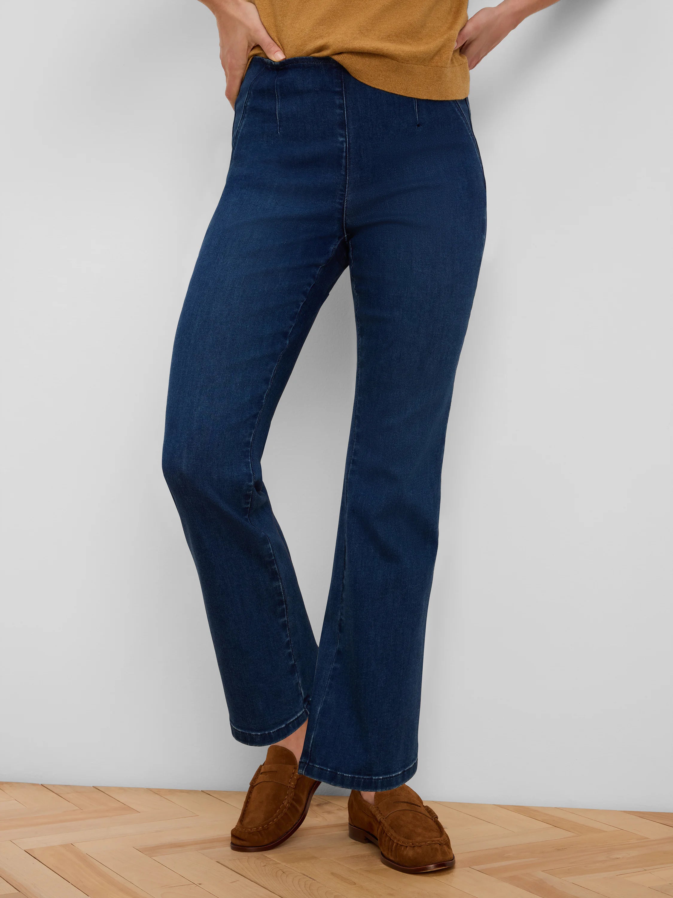 Dark blue boot-cut jeans featuring a pull-on waist and a subtle center seam down each leg.