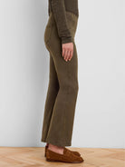 Olive green boot-cut jeans, fitted through the thigh and flaring below the knee.
