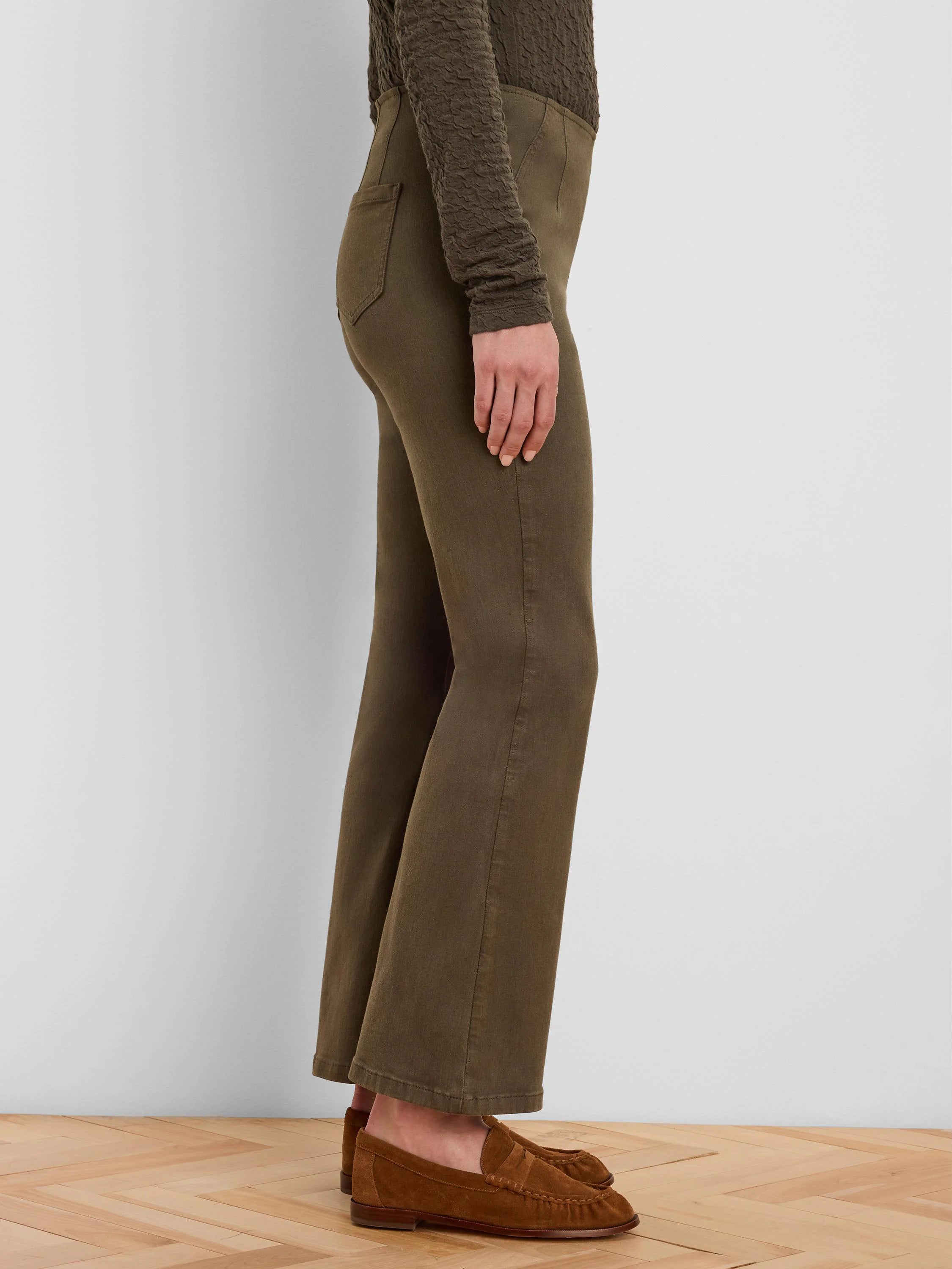 Olive green boot-cut jeans, fitted through the thigh and flaring below the knee.