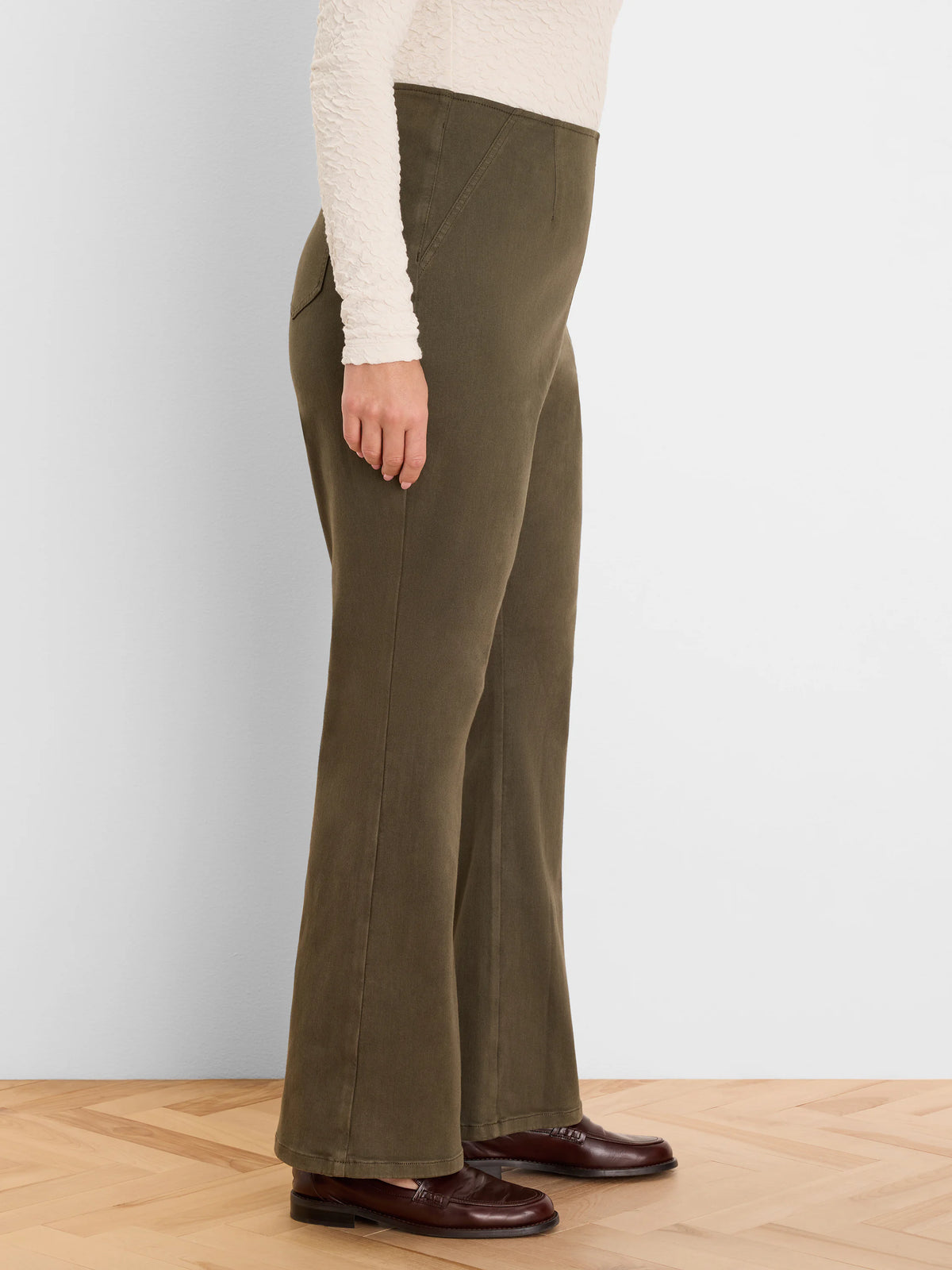 Dark olive green, high-waisted bootcut jeans with front vertical seams. Worn by a model.