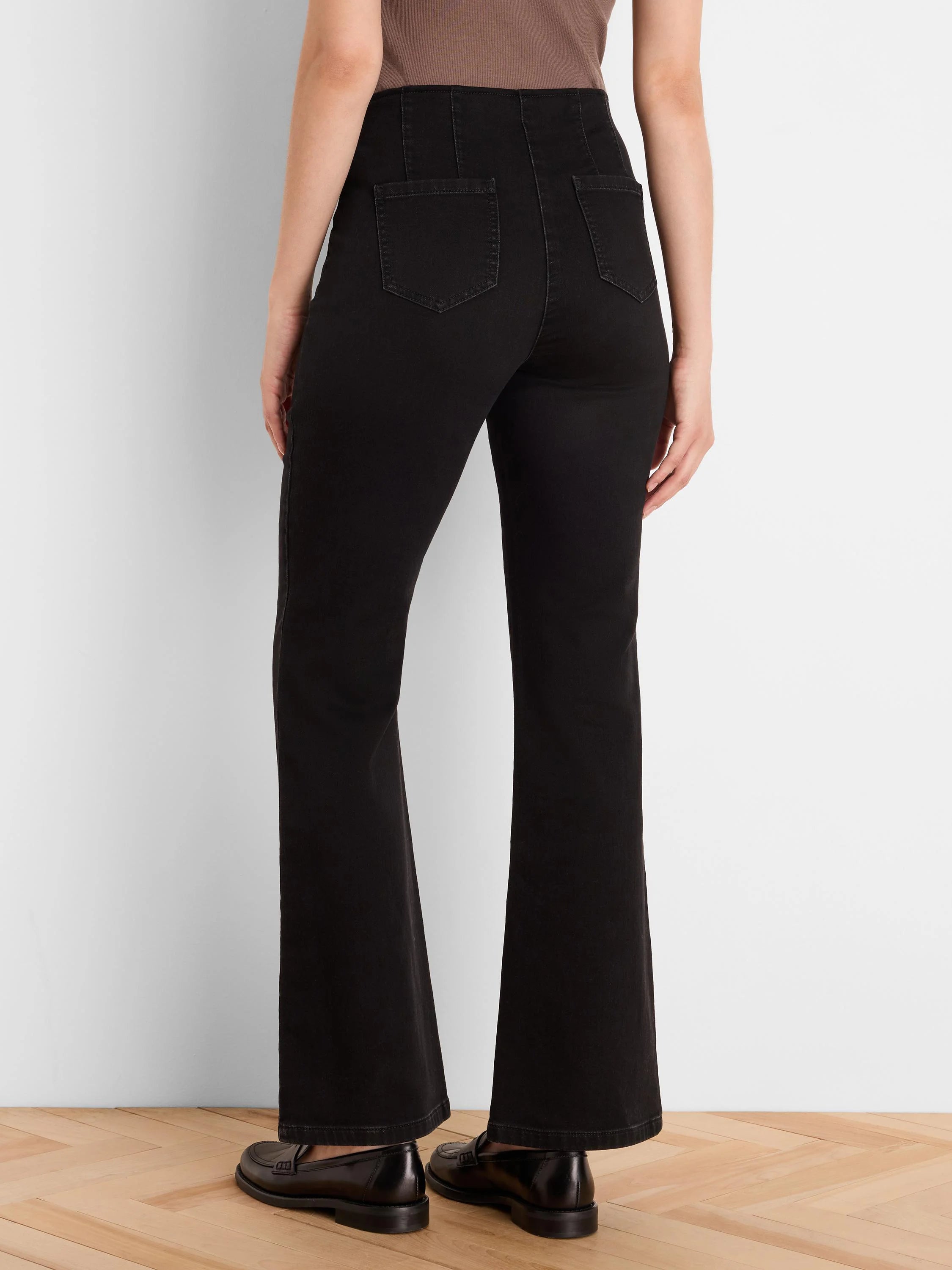 Black high-waisted bootcut jeans, rear view. Features back patch pockets and flared leg openings.