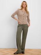Olive green wide-leg pants featuring angled front pockets and visible stitching, worn by a model.