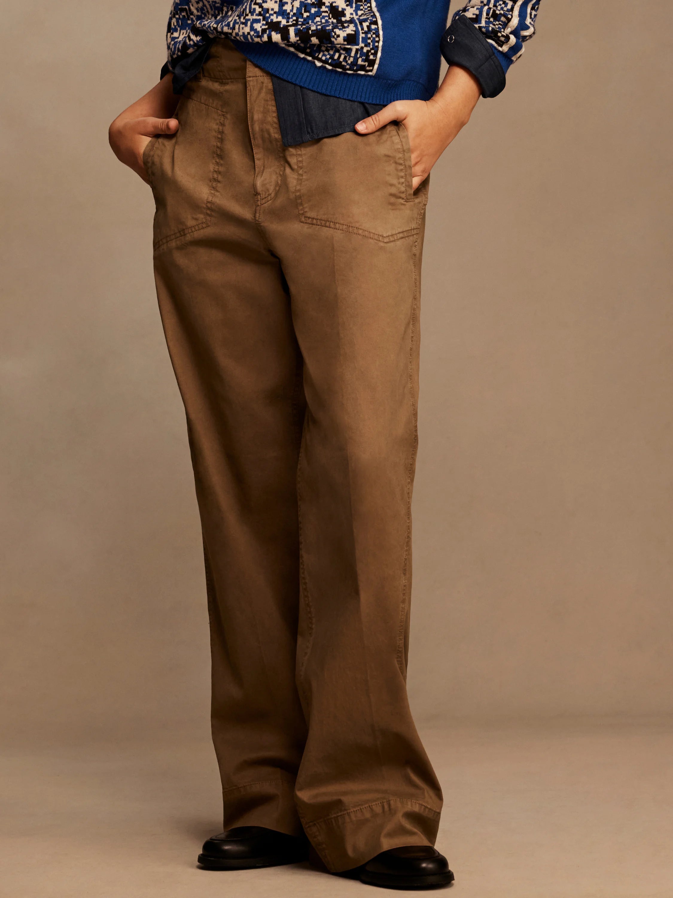 Brown wide-leg pants with angled front pockets, belt loops, and visible stitching details.