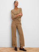 Tan wide-leg pants with angled front pockets, prominent stitching, and cuffed hems.