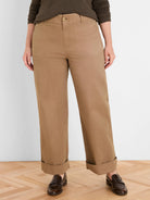 Tan wide-leg pants with cuffed hems, angled front pockets, and a button closure.