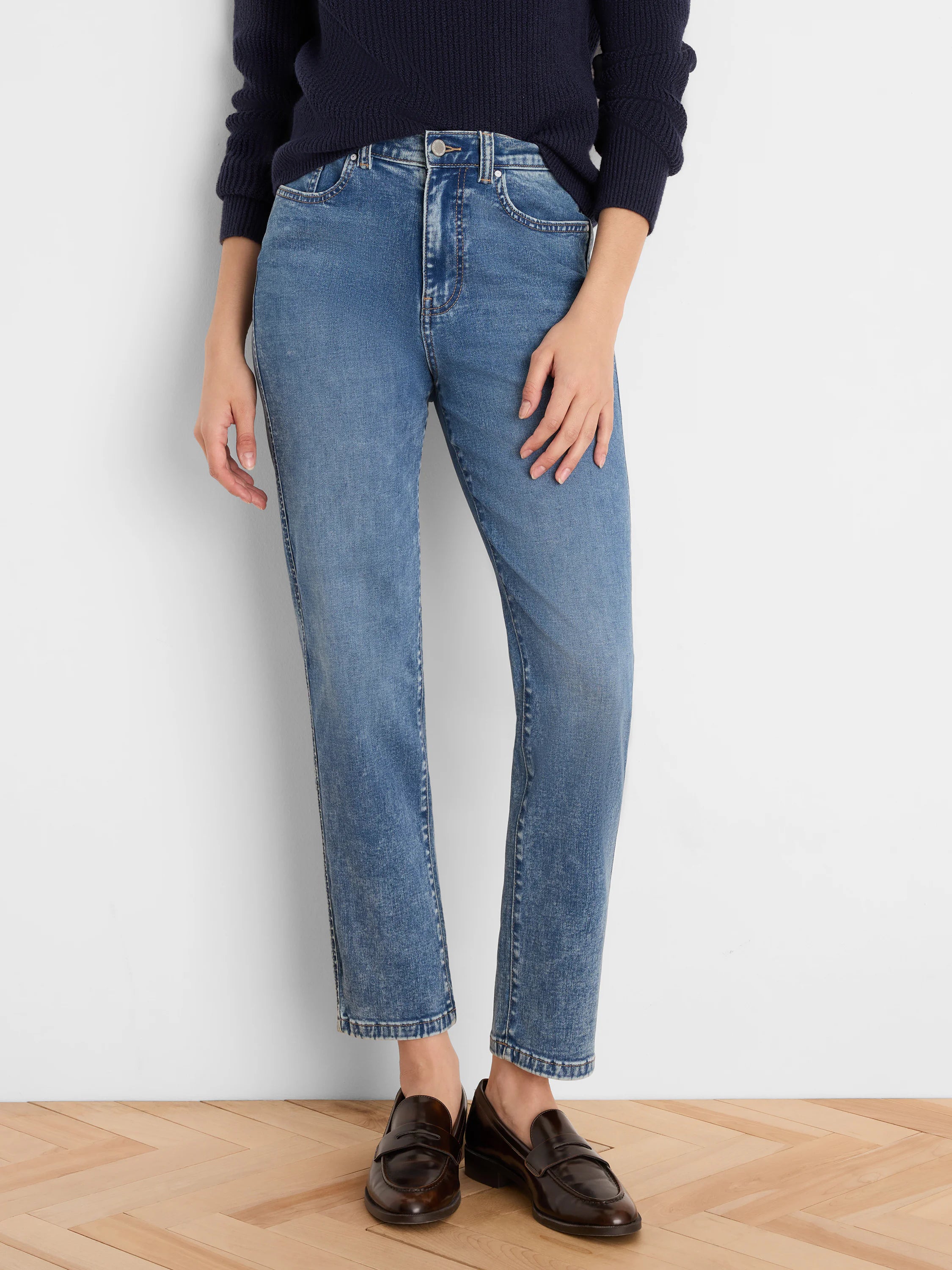 Medium blue straight leg jeans with a faded wash, high waist, and slightly cropped length.