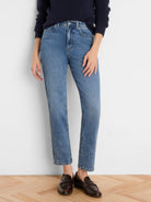 Medium blue straight leg jeans with a faded wash, high waist, and slightly cropped length.