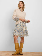 Cream chiffon dress with abstract blue and tan floral print. Features a collared neckline, voluminous sleeves, and a...
