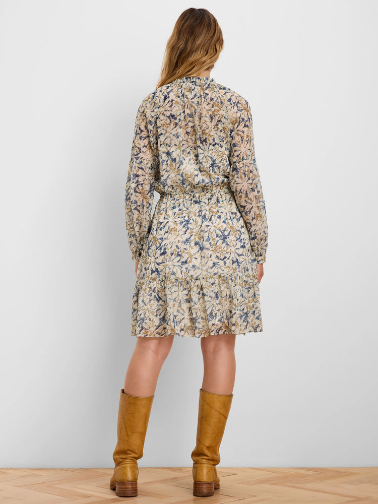 Cream chiffon dress with blue/gold floral pattern, long sleeves, elastic waist, tiered short skirt. Back view.