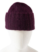 Dark plum hand-knit hat with a ribbed cuff, fuzzy texture, and a flat top.