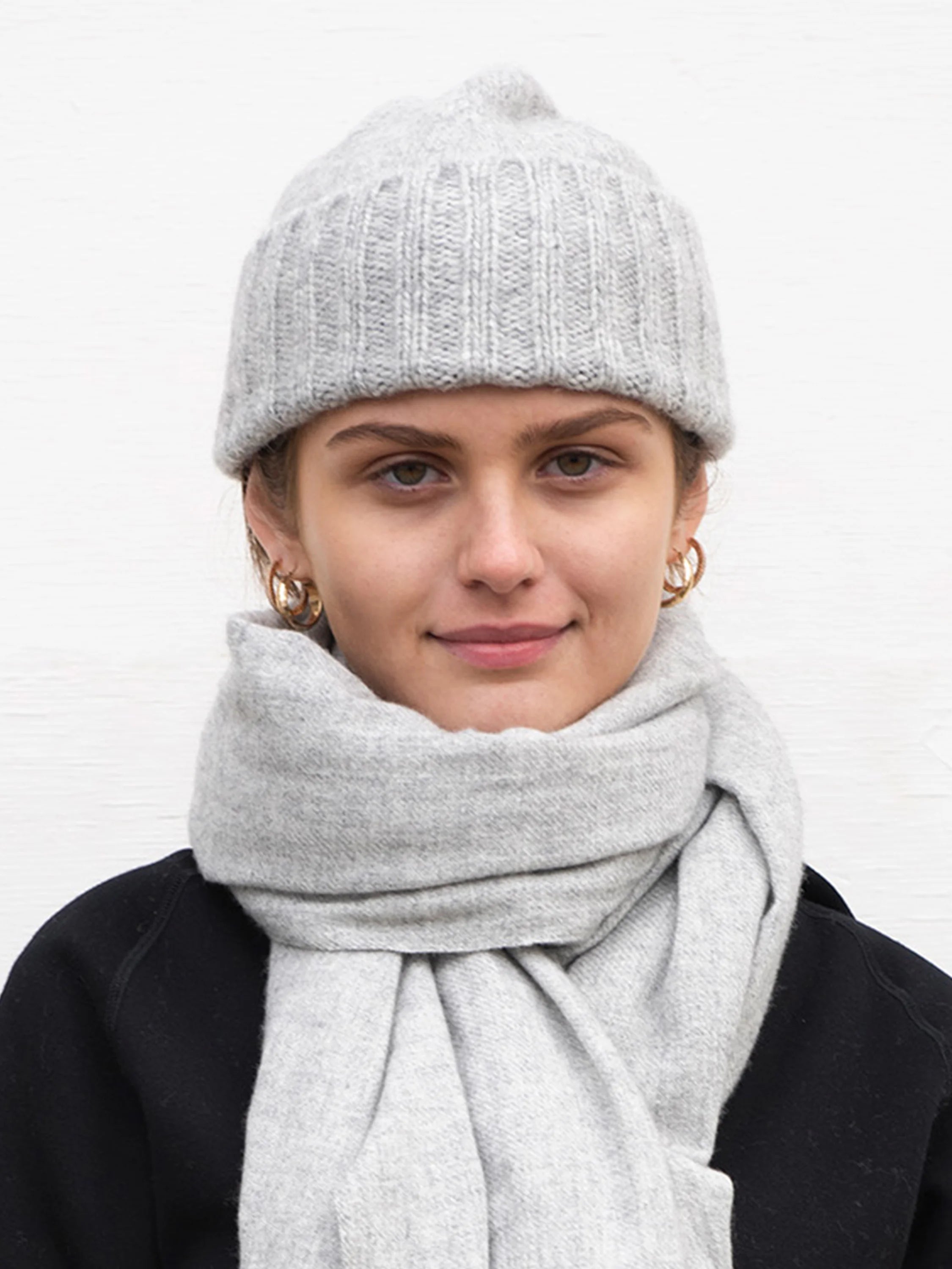 Light grey, hand-knit flat hat with a ribbed texture.