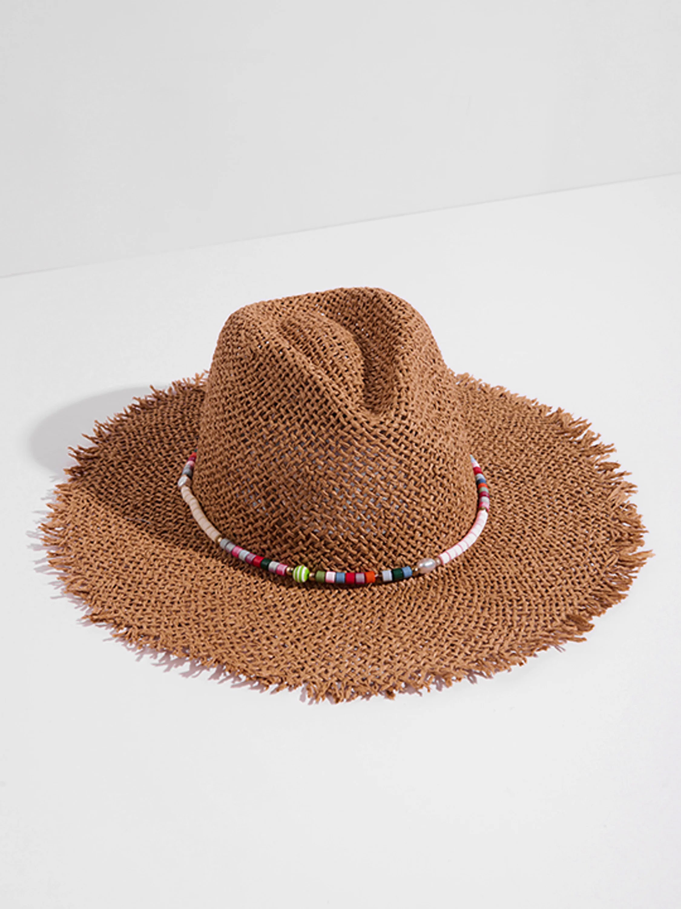 Brown woven straw hat with frayed edges.  A band of multicolored beads circles the crown.