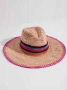 Beige straw rancher hat with pink trim and multicolored stripes.