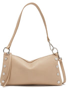 Light beige pebbled leather bag with curved top, silver dome studs, top zipper, and thin shoulder strap.