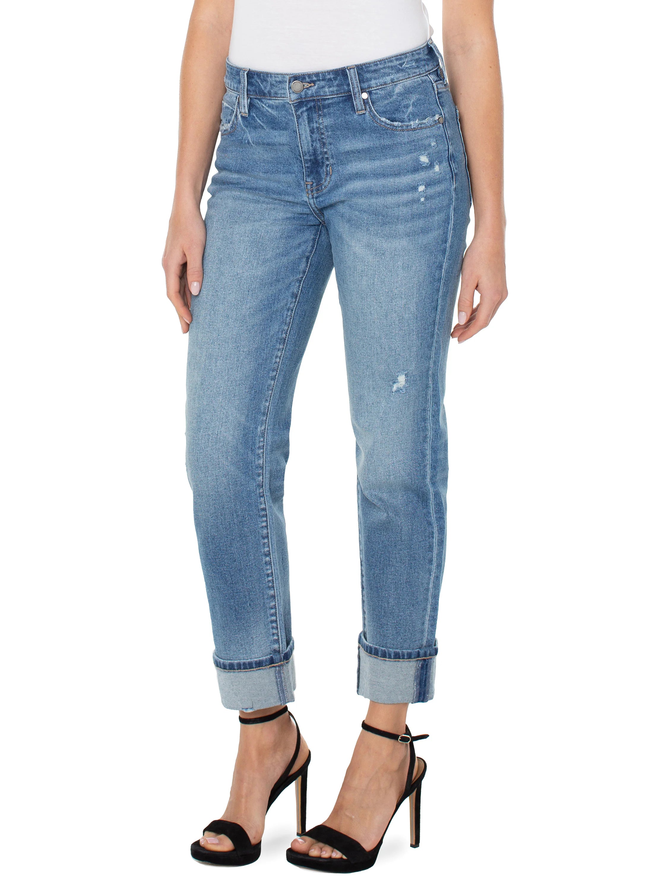 Light-wash blue jeans, rolled cuffs, distressed details.  Model wears black heels.