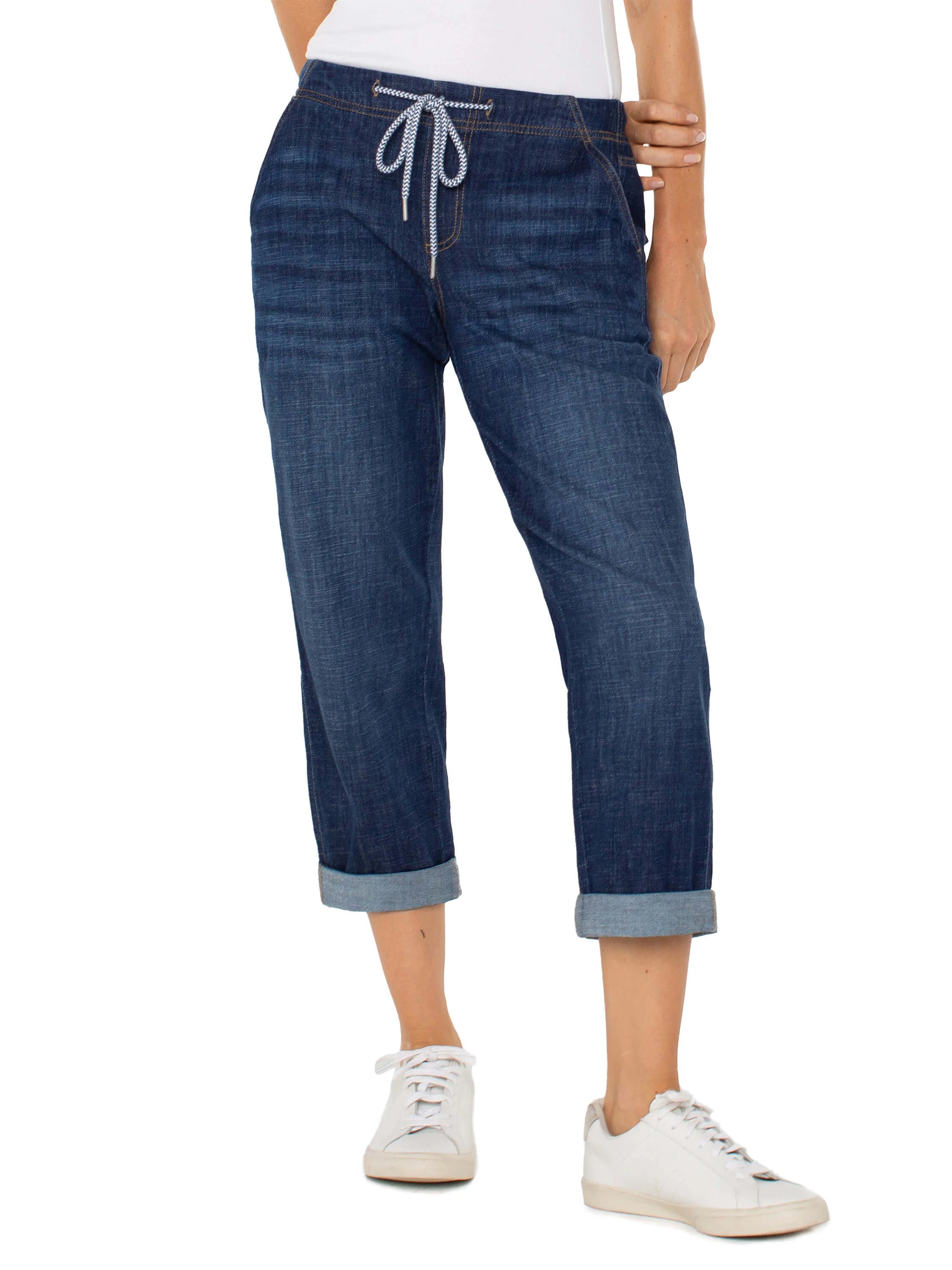 Dark wash denim jeans; cuffed hems; drawstring waist with white and black pattern; back pockets.