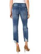 Here's alt text for the image, under 125 characters:

"Medium-wash blue denim jeans, cropped, slightly distressed at the...