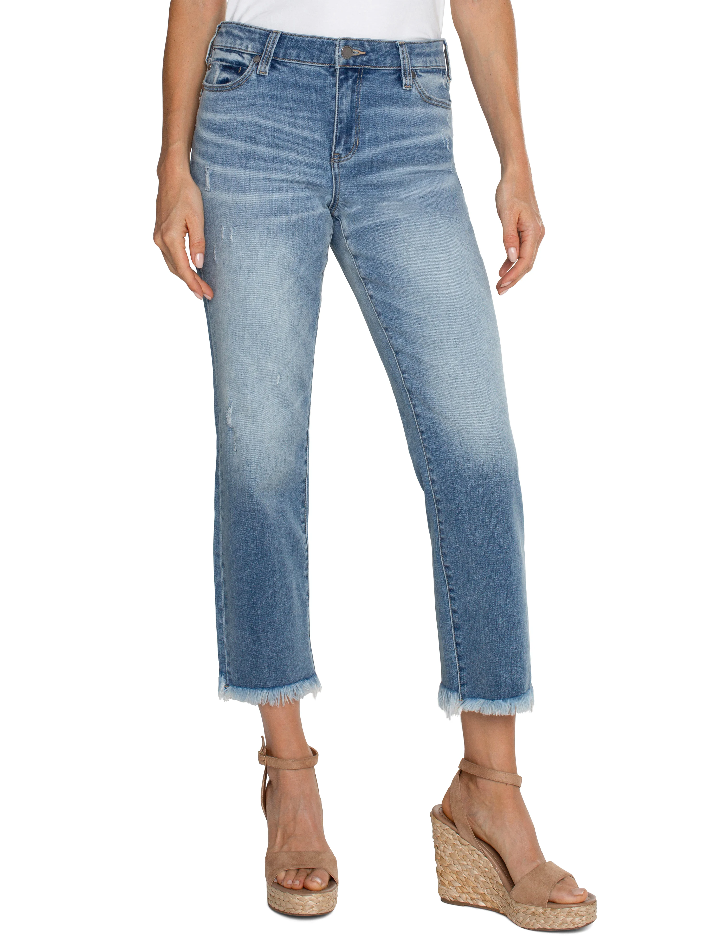 Light wash denim cropped straight leg jeans with frayed hems.  Distressed areas visible. Model wears tan wedge sandals.