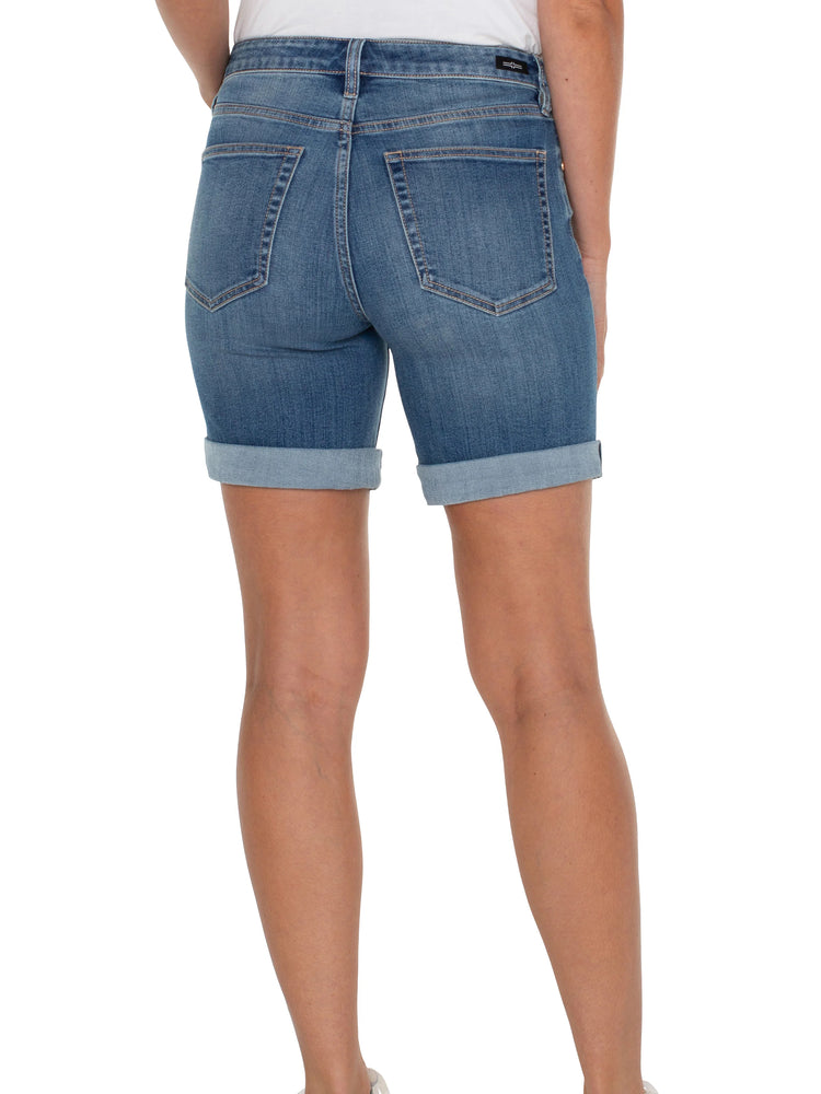 Here's alt text for the image, suitable for visually impaired users:

"Mid-wash blue denim shorts, cuffed at the hem,...