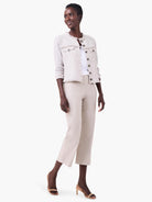 White jersey split neck tank, partially visible on a model underneath a light-colored jacket.