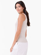 Light beige sleeveless tank top, fitted, with wide straps, shown on a woman from the side.