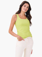 Lime green square-neck tank top, fitted. Model wears it with cream pants.