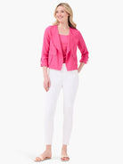 Bright pink scoop neck tank top worn by a model, partially visible under an open pink jacket.