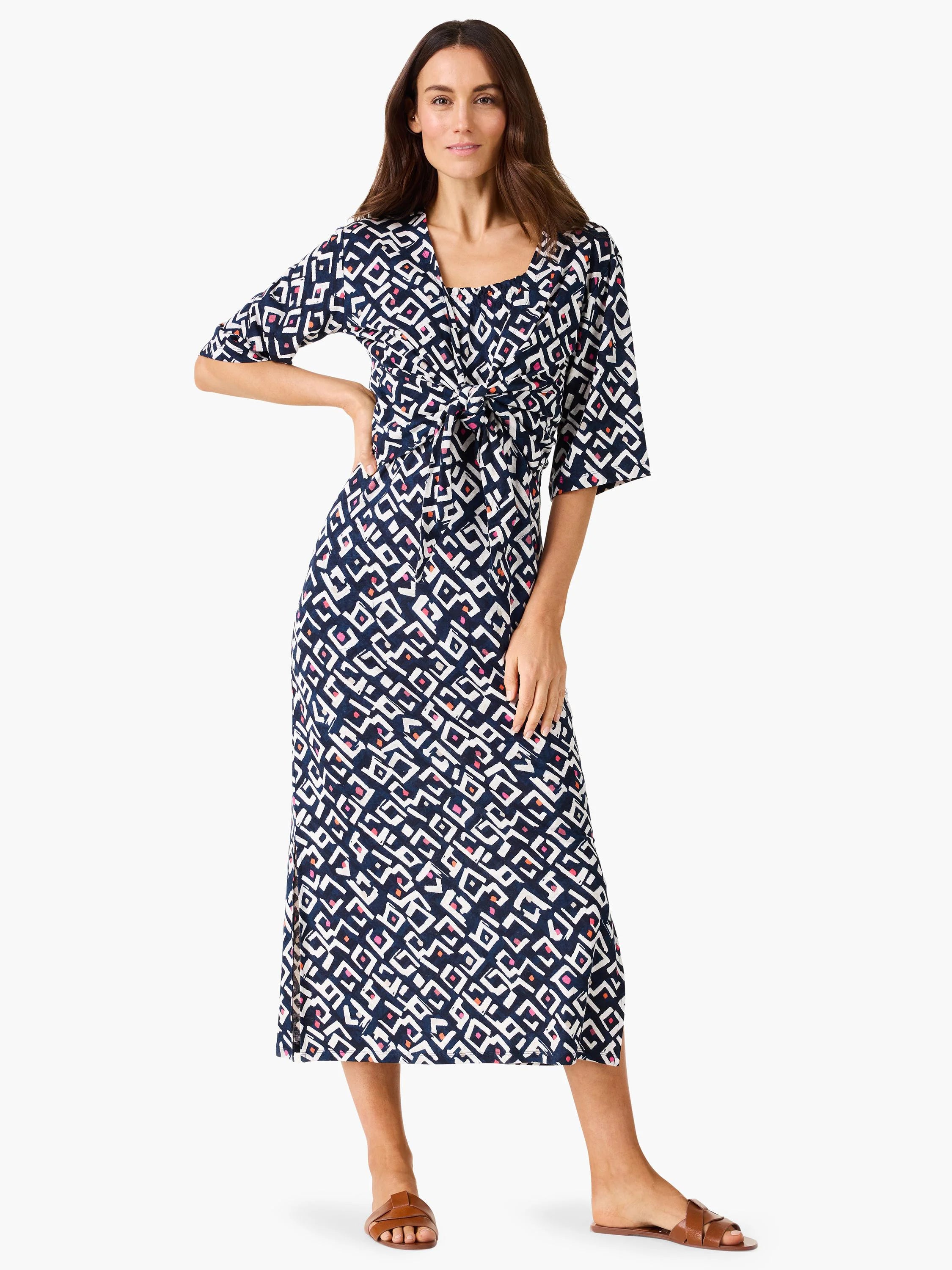 Dark blue geometric pattern cardigan with white, pink, & orange shapes, tied at waist, V-neck, elbow sleeves, midi length.