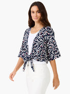 Indigo cardigan with white, pink, and orange geometric angle pattern. Short sleeves, tied at waist over white top.