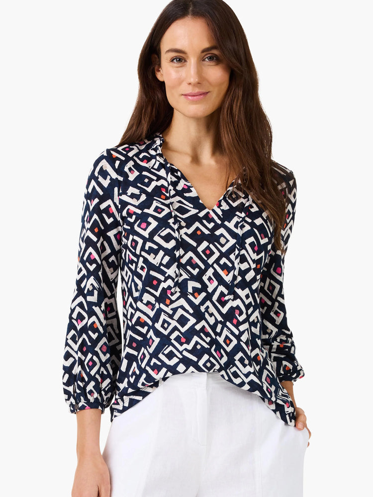 Indigo top with white geometric pattern and pink/orange accents, V-neck with tie, 3/4 sleeves.
