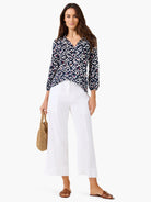 Dark blue V-neck top with geometric pattern in white, pink, and light blue. Features 3/4 sleeves.