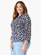Dark blue top with white, pink, orange geometric angle pattern, V-neck, 3/4 sleeves.