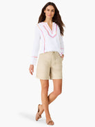 White long-sleeve V-neck top with colorful geometric embroidery in pink, orange, and purple on the neckline and cuffs.