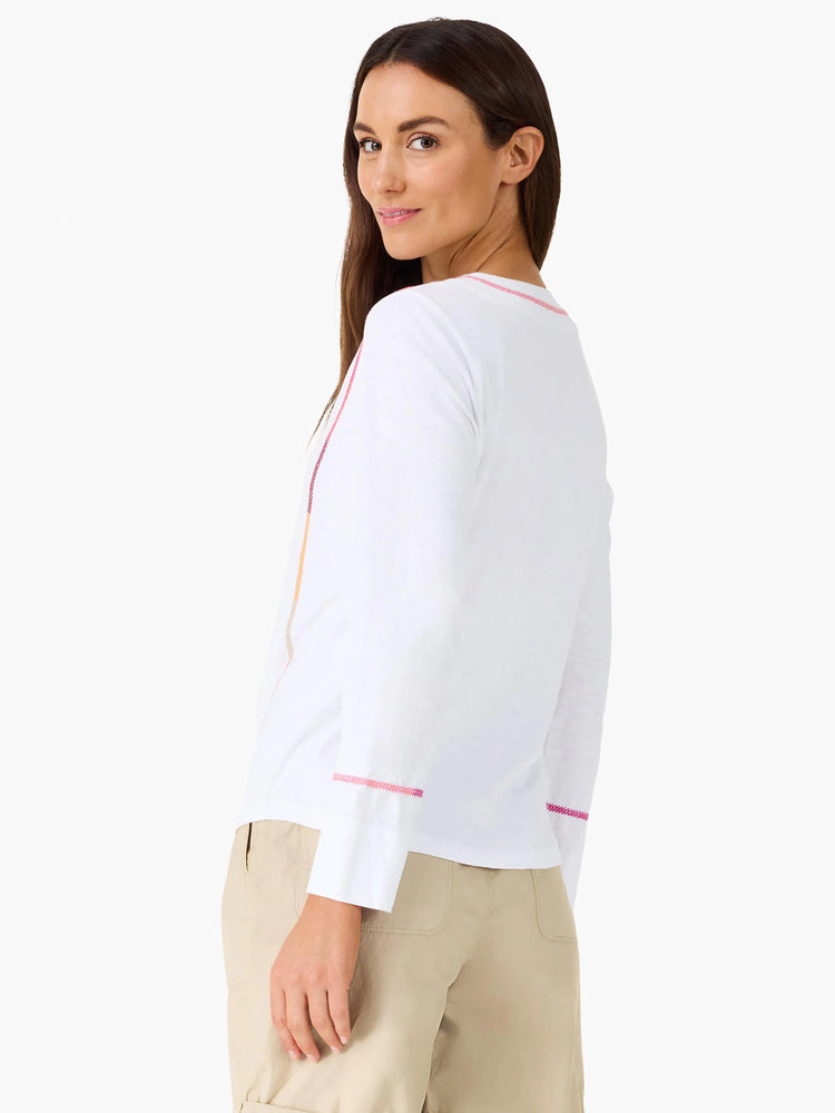 White long-sleeve top with pink, fuchsia, & orange embroidered trim on shoulders & cuffs.