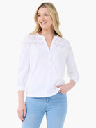 White top with eyelet lace yoke, V-neck, 2-button placket, and 3/4 sleeves.