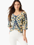 Abstract patterned V-neck top with 3/4 sleeves in dark blue, olive green, beige, and teal hues.