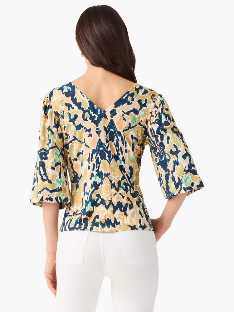 Vineyard Glow Top, back view. Abstract print in navy, yellow, green, cream, teal. V-neck, 3/4 bell sleeves.