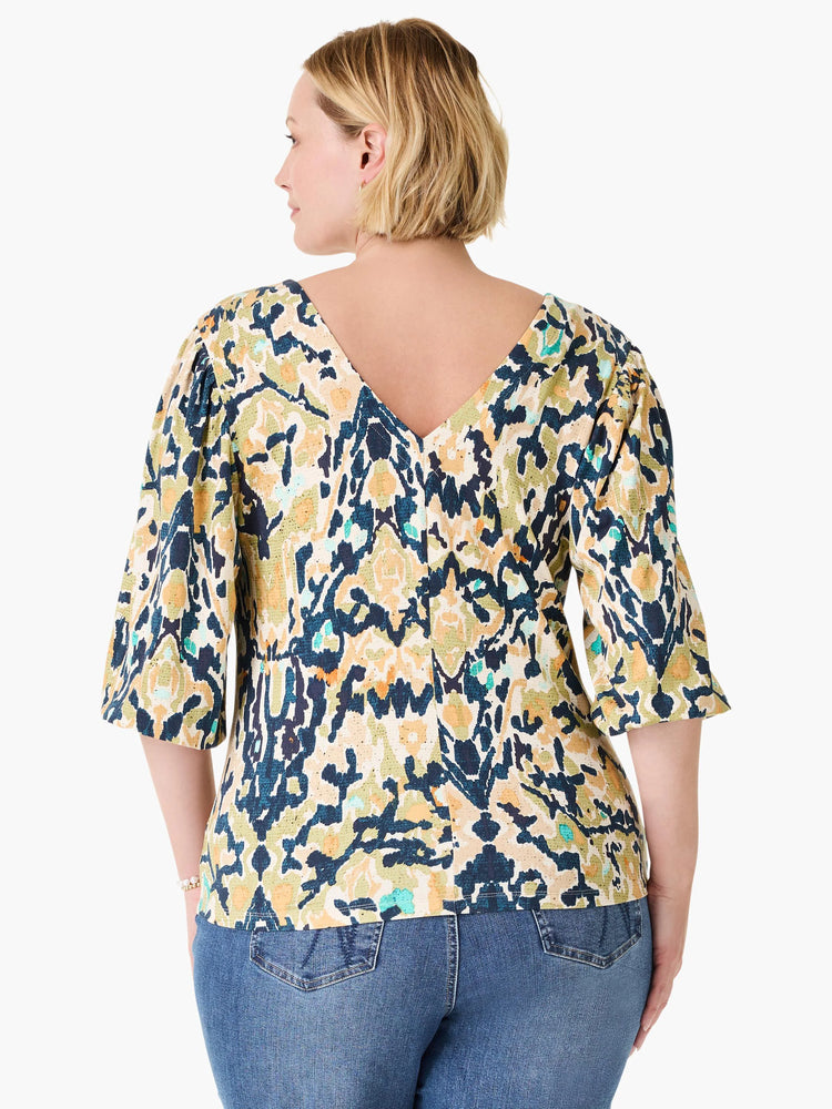 Back view of a multi-color top with dark blue, olive, mustard, beige, teal abstract pattern. Features a V-neck back and...