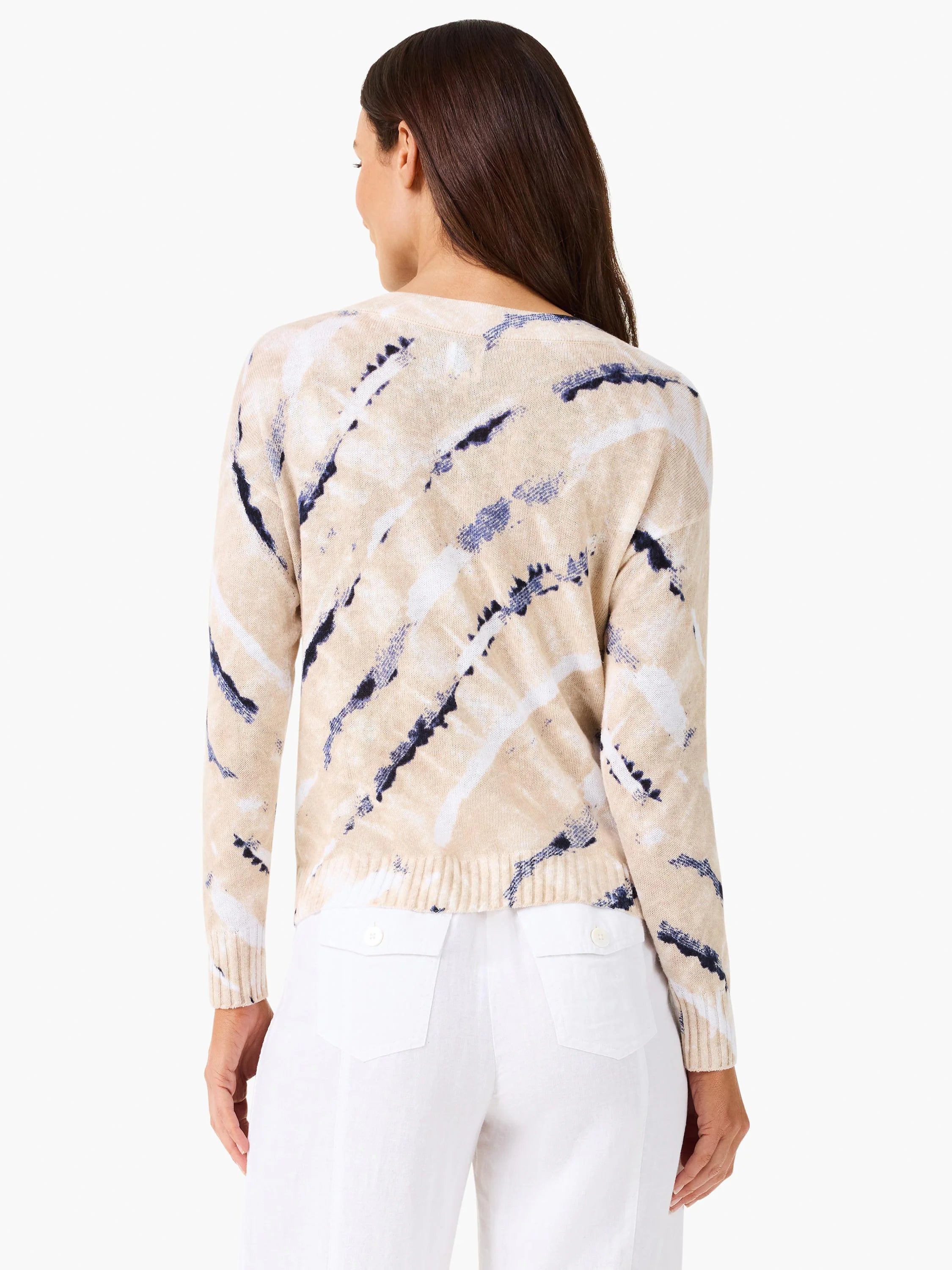 Back view of a sweater. Beige with white and navy irregular stripes, resembling tie-dye. Ribbed cuffs and hem.