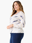 Off-white V-neck sweater with indigo tie-dye, long sleeves, and ribbed cuffs and hem.