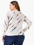 Cream sweater with irregular navy blue abstract streaks, ribbed cuffs & hem. Shown from the back.