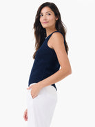 Navy high neck tank top with a visible ribbed knit texture, modeled with white pants.