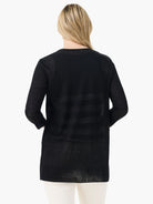 Black sheer long-sleeve cardigan with ribbed cuffs, extending past hips, worn from behind over light pants.
