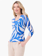 Blue and off-white abstract pattern cardigan with 3/4 sleeves. It has a wrapped front and a single button closure.